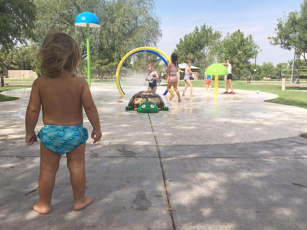 Toddler Looking at Other Kids Playing on the Splash Pad